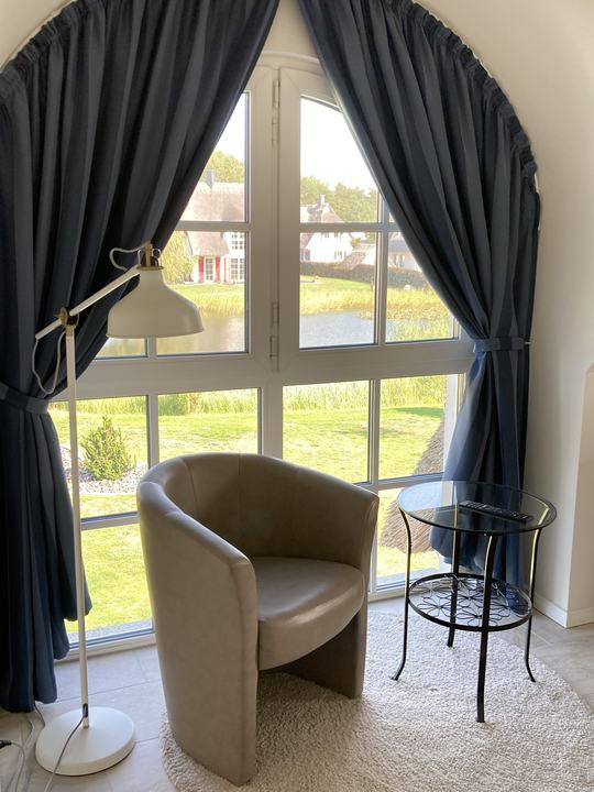 Leseplatz am Rundbogenfenster mit Blick auf den Teich